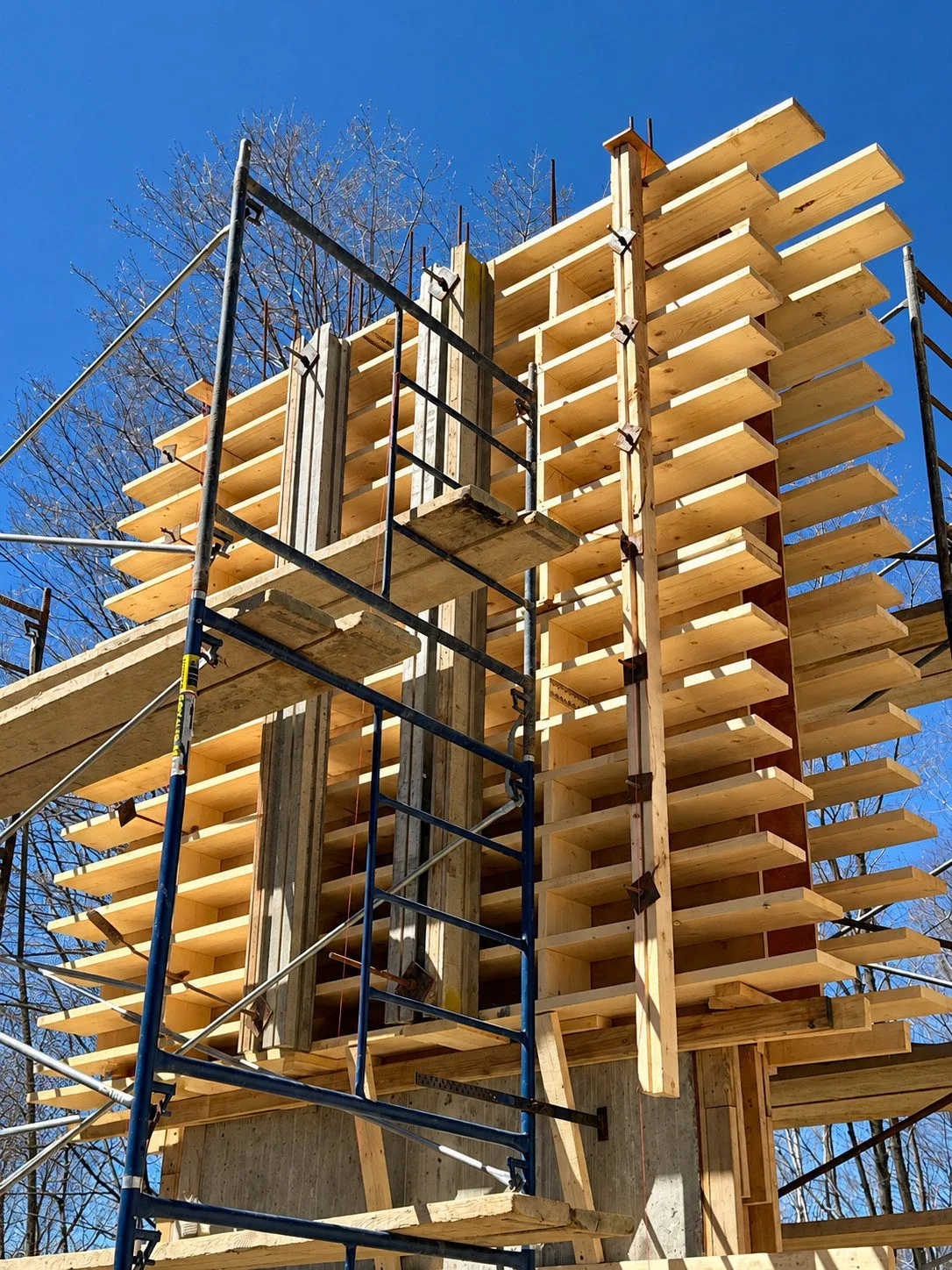 Coffrage de béton complexe en bois avec échafaudage sur un chantier de construction de Créations CGC.
