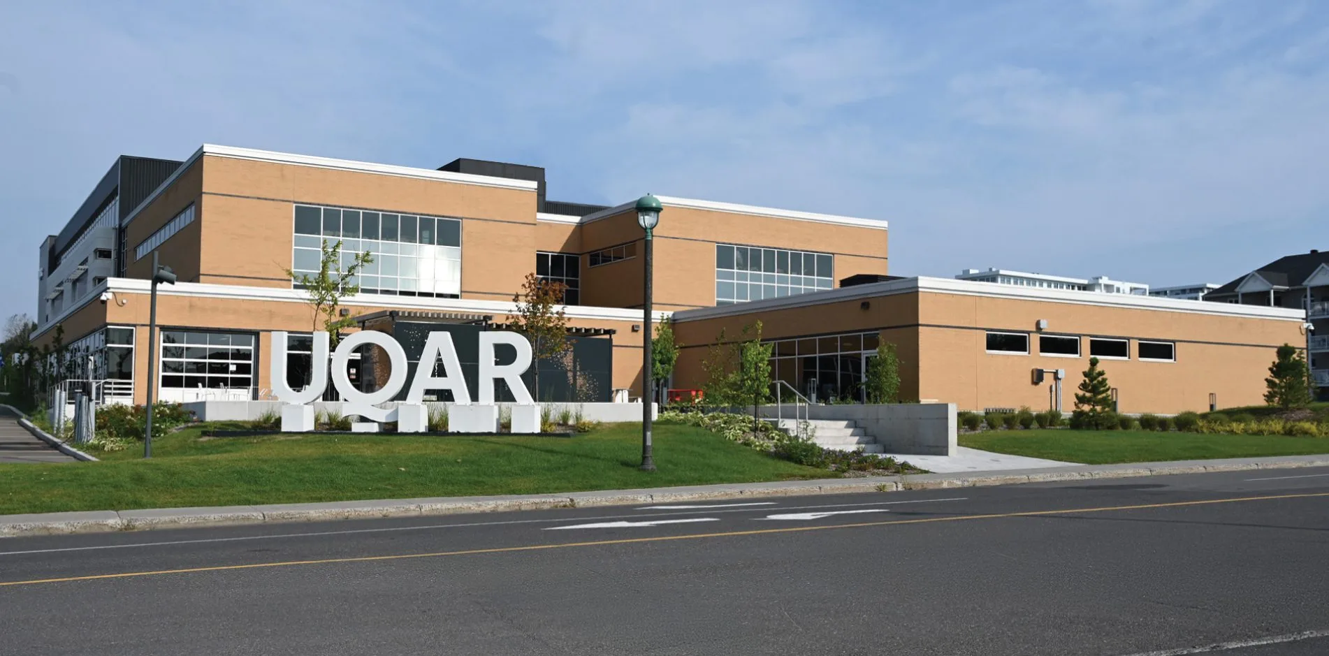 Vue extérieure du bâtiment de l’UQAR à Lévis, où Créations CGC a réalisé des travaux de coffrage pour des bases de lettrage et des murets paysagers.